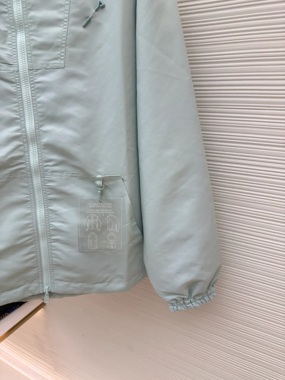 LOUIS VUITTON double-sided windproof pin jacket ●Authentic product: purchased and developed for 22800 ●Item number: 1680473-C55 ●Fabric: polyester fiber fabric ●Technology: jacquard ●Version: fitted version ●Weight: about 565 grams ●Size: 44-46-48-50 ●Description: The solid color fabric is made of nylon encrypted matt twill fabric, and the jacquard fabric on the other side is made of 50D nylon yarn-dyed jacquard fabric. The solid color front panel is laser-burned, hand-made of white copper, with a triangle pin with logo and glossy finish. The front panel pocket uses a hardware keychain to hang a folding clothing tag, and the jacquard letters on the front chest placket are made of single-piece flowing pure It is cut by hand to restore the flower, and all the pieces are numbered. The pockets are also cut with the restored flower number. The fabric is relatively light and silky, and it takes time to cut accurately. The front and center are equipped with a double-circulation puller 5# orbital zipper. The hem and the hood are worn with spiral elastic ropes with ring anti-slip buckles, square pig nose buckles with logo, and all holes are punched with hardware and logo on the cloth-colored cornrows.